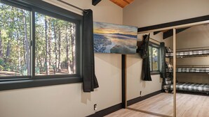 A room with a large window, a bunk bed, and a painting of a landscape. - Timber Wolf Tavern - Walk to Slopes, Game Room, Pool Table (Big Bear Lake)