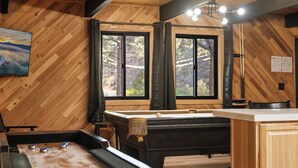A pool table in a room with wooden walls and large windows. - Timber Wolf Tavern - Walk to Slopes, Game Room, Pool Table (Big Bear Lake)