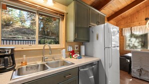 A kitchen with a double sink, stainless steel appliances, and wooden cabinets.
