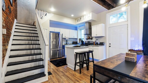 A modern kitchen with a wooden island, white cabinets, and a stainless steel refrigerator.