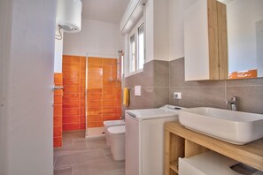 Een douche, een haardroger, een bidet, handdoeken