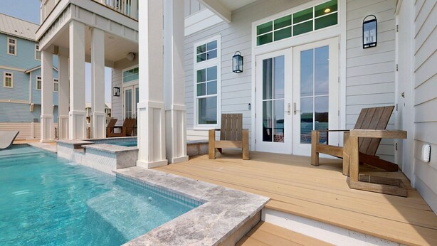 A pool area with a wooden deck, a covered seating area, and a view of the ocean. - SBT115 Private Pool, Pickleball Court, Sauna, Boardwalk to the Beach (Port Aransas)