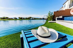 A poolside area with a blue lounge chair and a white hat. - Lakeside Living! WOW! Sleeps 10! 4 Primary Suites (Indio)