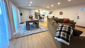A modern apartment with a dining area, kitchen, and living room.