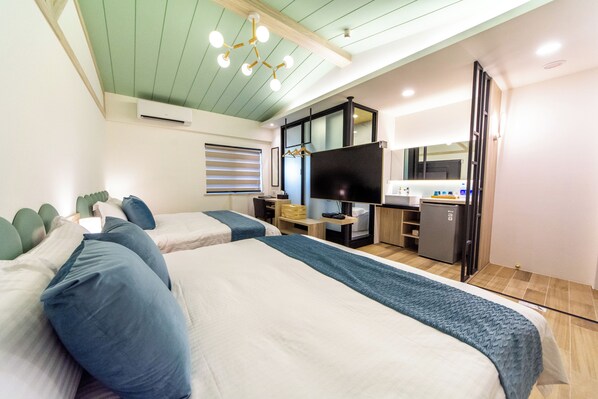 A hotel room with two beds, a desk, a television, and a minibar. - W Cube (Tainan)