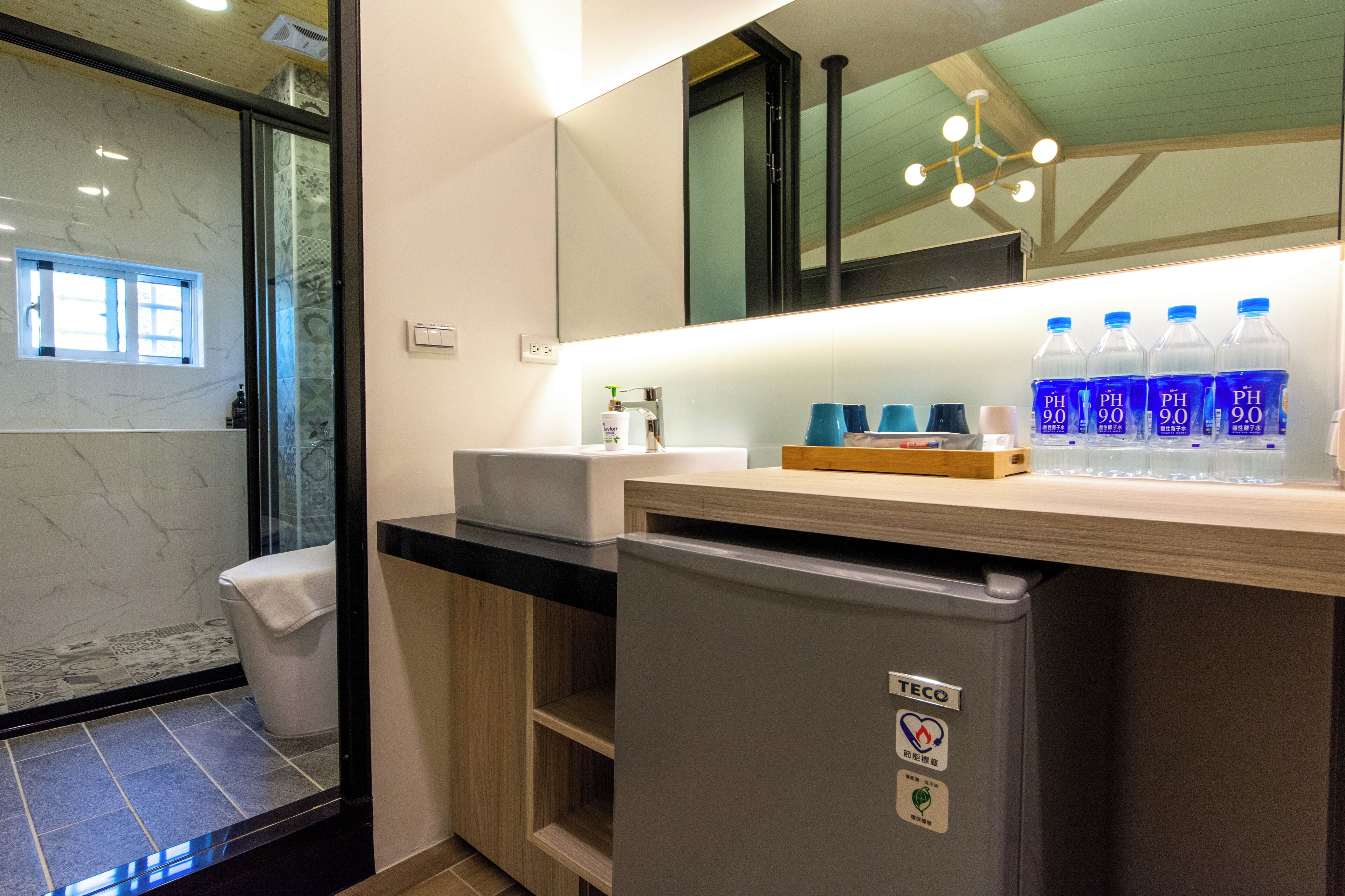 A modern bathroom with a marble vanity, a built-in sink, and a refrigerator.