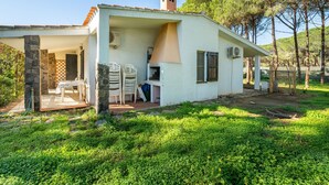 A white house with a patio, stone pillars, and a chimney. - Vacation home Itaca by Interhome (Villasimius)