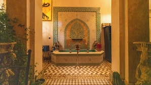 A bathroom with a checkered floor, a sink, and a decorative wall with a floral pattern. - Palais Nejma (Marrakech)