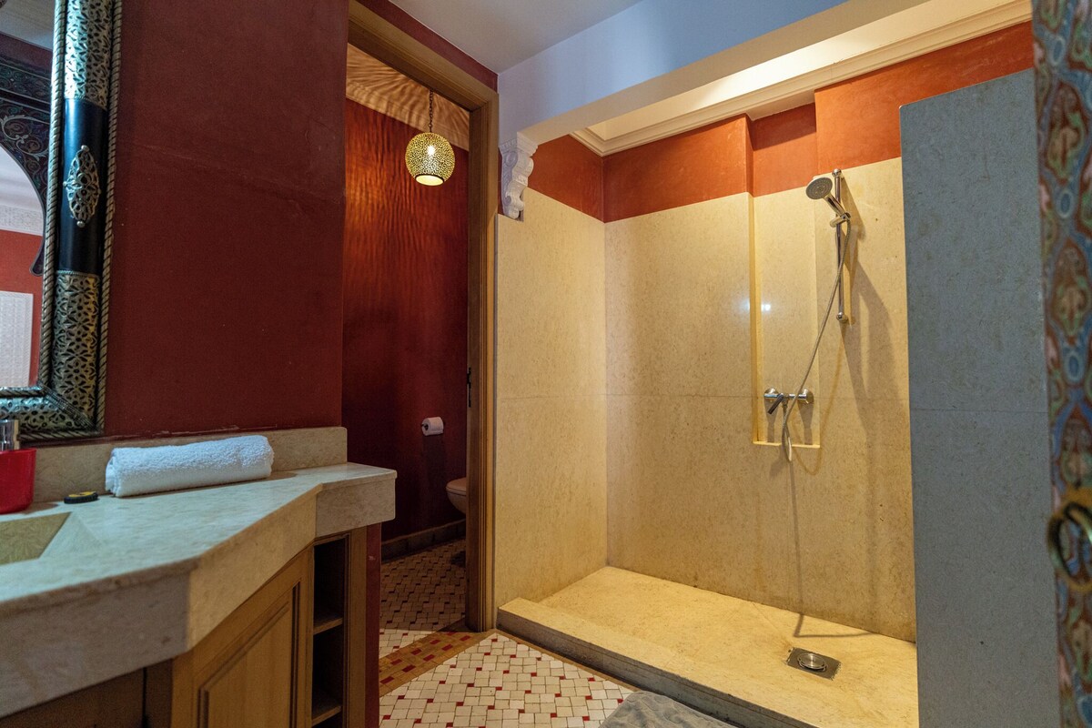 A bathroom with a shower, a sink, and a mirror.