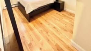 A bedroom with a bed, a nightstand, and a window. - Harrel Vacation Rentals (Omaha)