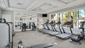 Ett gym med löpband, styrketräningsmaskiner och en träningsbänk.