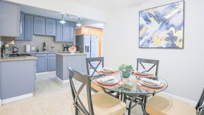 A modern kitchen with grey cabinets, a dining table with four chairs, and a large abstract painting on the wall. - Sunnyvale 3B2b Super Big House (Sunnyvale)
