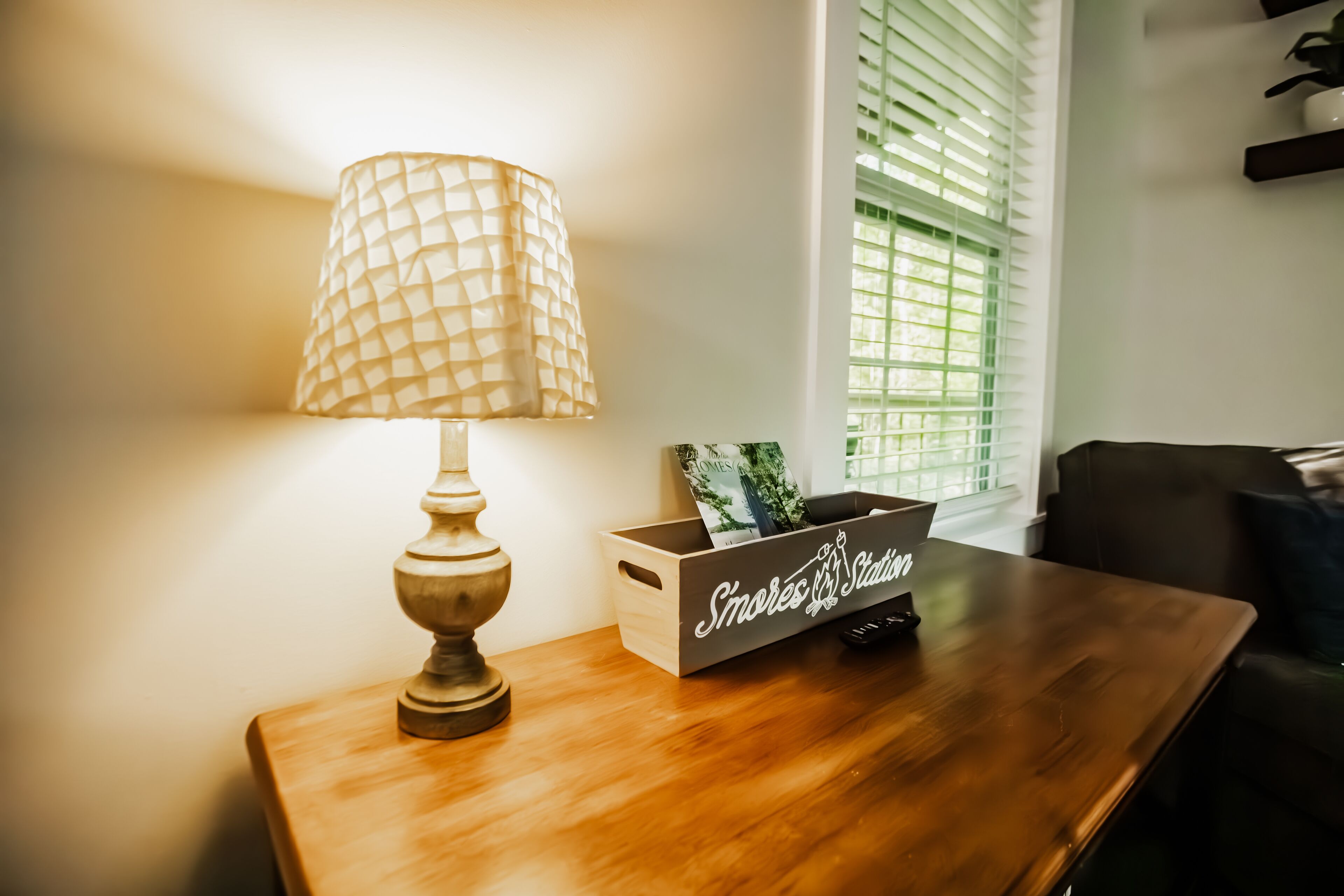 A wooden table with a lamp and a box labeled "S'mores Station."