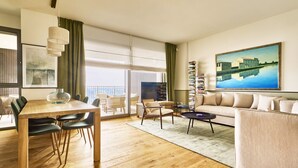 Una sala moderna con una mesa de comedor de madera, un sofá y una estantería.