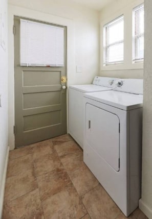 A laundry room with a door, a washing machine, and a window. - Beautiful 2 bedroom Victorian home (Vallejo)