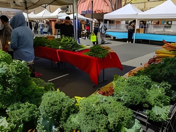 A market stall with various vegetables displayed on a red table. - Beautiful 2 bedroom Victorian home (Vallejo)