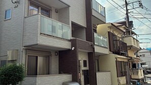 A multi-story residential building with balconies, a mail slot, and a visible entrance. - Gaia BOSCO by Tranova (Tokyo)