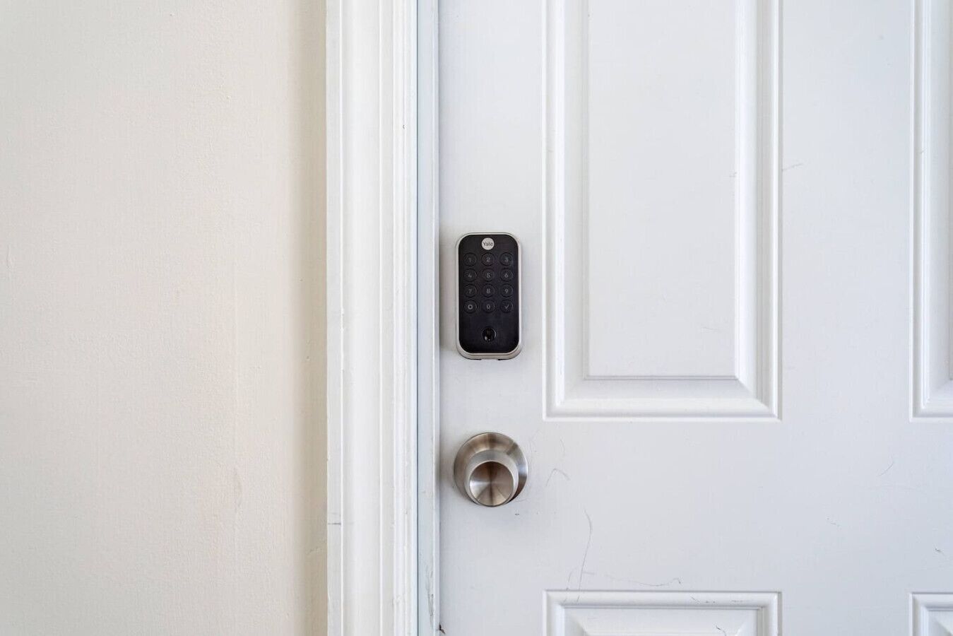 Une porte blanche avec un interphone et un trou de serrure.