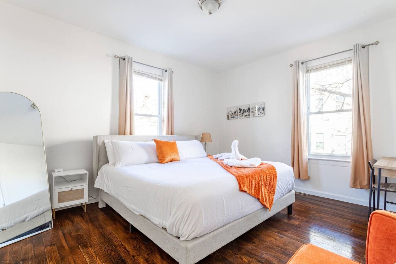 Un dormitorio con cama, mesitas de noche, escritorio y silla.