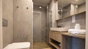 A modern bathroom with a shower, toilet, and vanity. - Costa Rogowo Romantyczne Studio Shellter Morze (Trzebiatow)