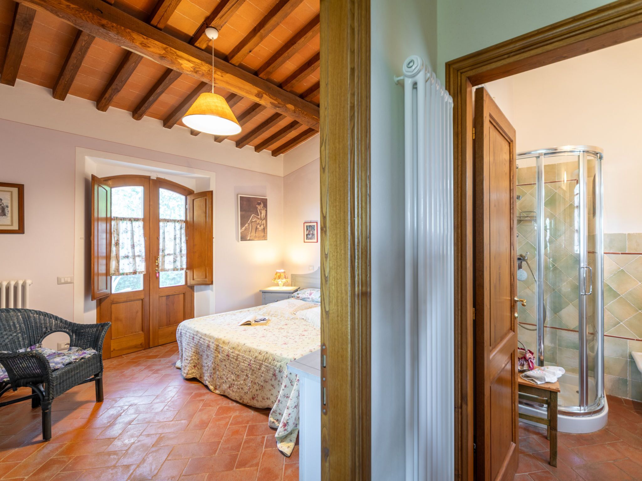 A bedroom with a bed, a chair, a window, and a door.