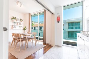A modern apartment with a dining area, a kitchen, and a balcony with a city view. - Acanto Loft by Atlantic Holiday (Funchal)