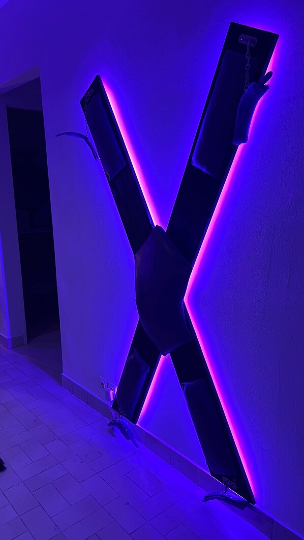Una llamativa instalación de luces con forma de X en una pared.