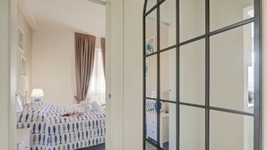 Un dormitorio con cama, mesita de noche, cómoda y espejo.