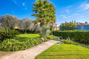 Un jardín cuidado con diversas plantas y un cielo despejado.