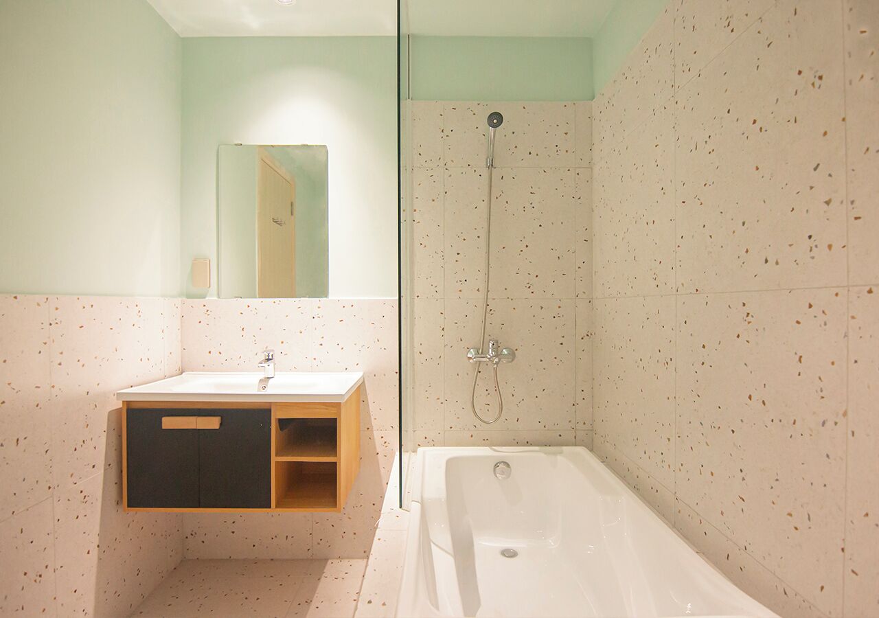 A modern bathroom with a freestanding bathtub, a glass-enclosed shower, and a wooden vanity with a mirror.