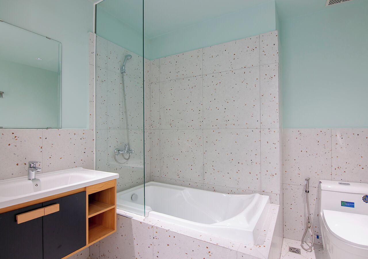A modern bathroom with a freestanding bathtub, a glass-enclosed shower, and a separate toilet area.