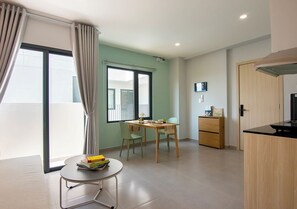 Enjoy a meal at the small dining table with two chairs, or relax in the kitchenette with a black countertop and wooden cabinet.
