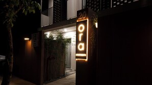 A building entrance with a neon sign reading "20 orai apartments" and a visible door. - ORA Serviced Apartments - Binh Duong New City (Ho Chi Minh City)
