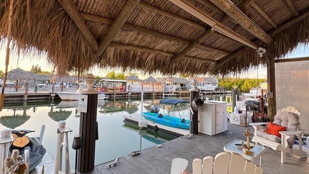 A covered outdoor area with a wooden deck, a pool, and lounge chairs. - Nice Water Front Tiny home w AC, WiFi include boat ramp & 20ft dock in KeyLargo (Key Largo)