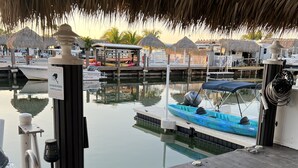 A wooden dock with a thatched roof, a pool, and a view of boats and a marina. - Nice Water Front Tiny home w AC, WiFi include boat ramp & 20ft dock in KeyLargo (Key Largo)