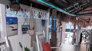 A beach-themed interior with rocking chairs, a welcome sign, and nautical decorations. - Nice Water Front Tiny home w AC, WiFi include boat ramp & 20ft dock in KeyLargo (Key Largo)