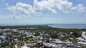 Un pueblo costero con un puerto deportivo, casas y una playa.