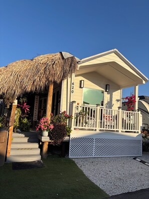 A building with a thatched roof, a covered porch, and a sign indicating a tropical theme.
