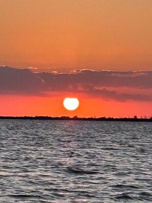 A sunset over a body of water with a silhouette of land in the distance. - Nice Water Front Tiny home w AC, WiFi include boat ramp & 20ft dock in KeyLargo (Key Largo)