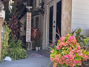 A wooden deck with a tropical-themed sign, potted plants, and a turtle statue. - Nice Water Front Tiny home w AC, WiFi include boat ramp & 20ft dock in KeyLargo (Key Largo)