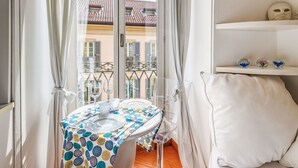 A bathroom with a toilet, a window with curtains, and a view of buildings outside. - Sant' Andrea Fashion Suite by Interhome (Milan)