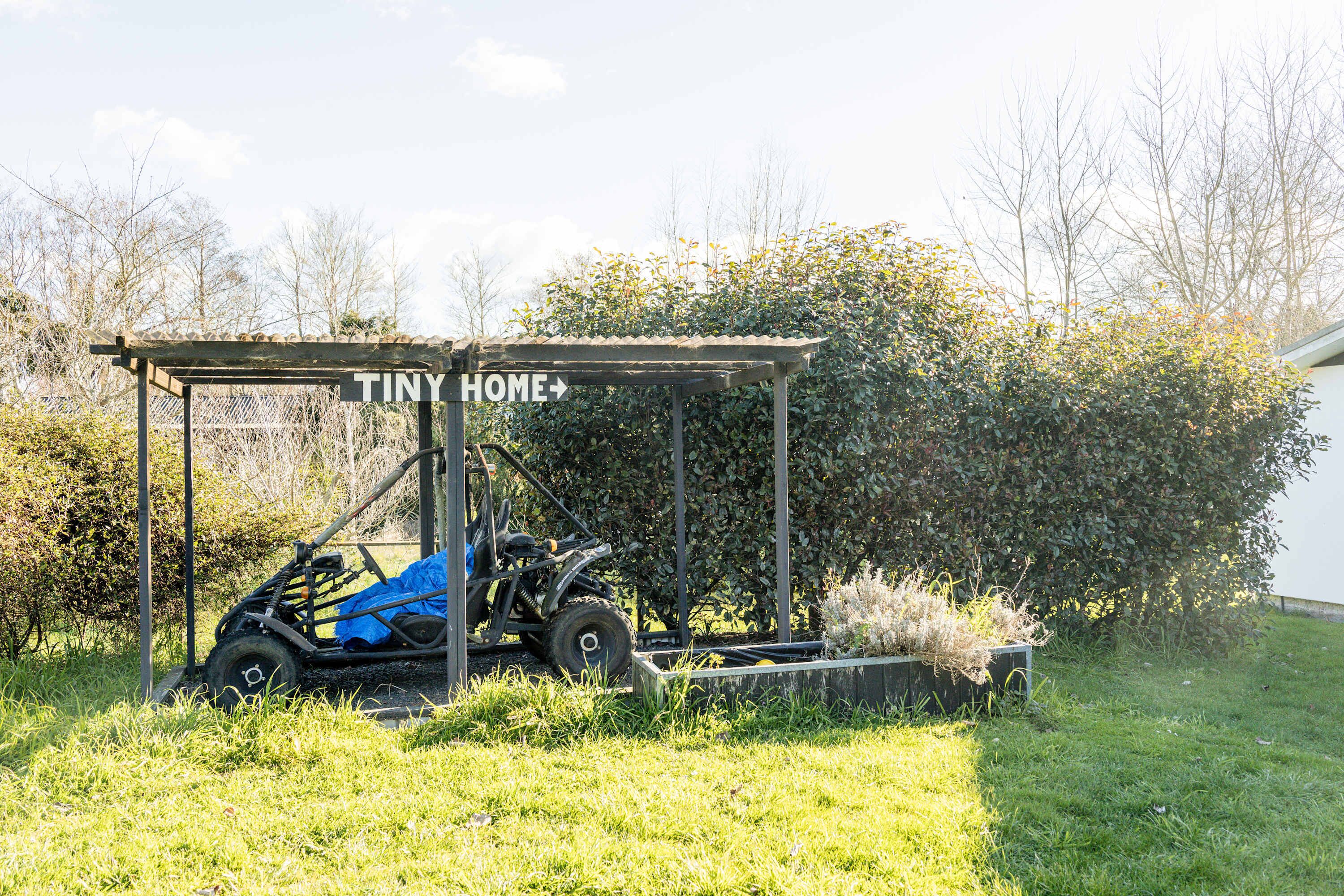 Un espacio al aire libre cubierto con un letrero que dice 'TINY HOME+'.