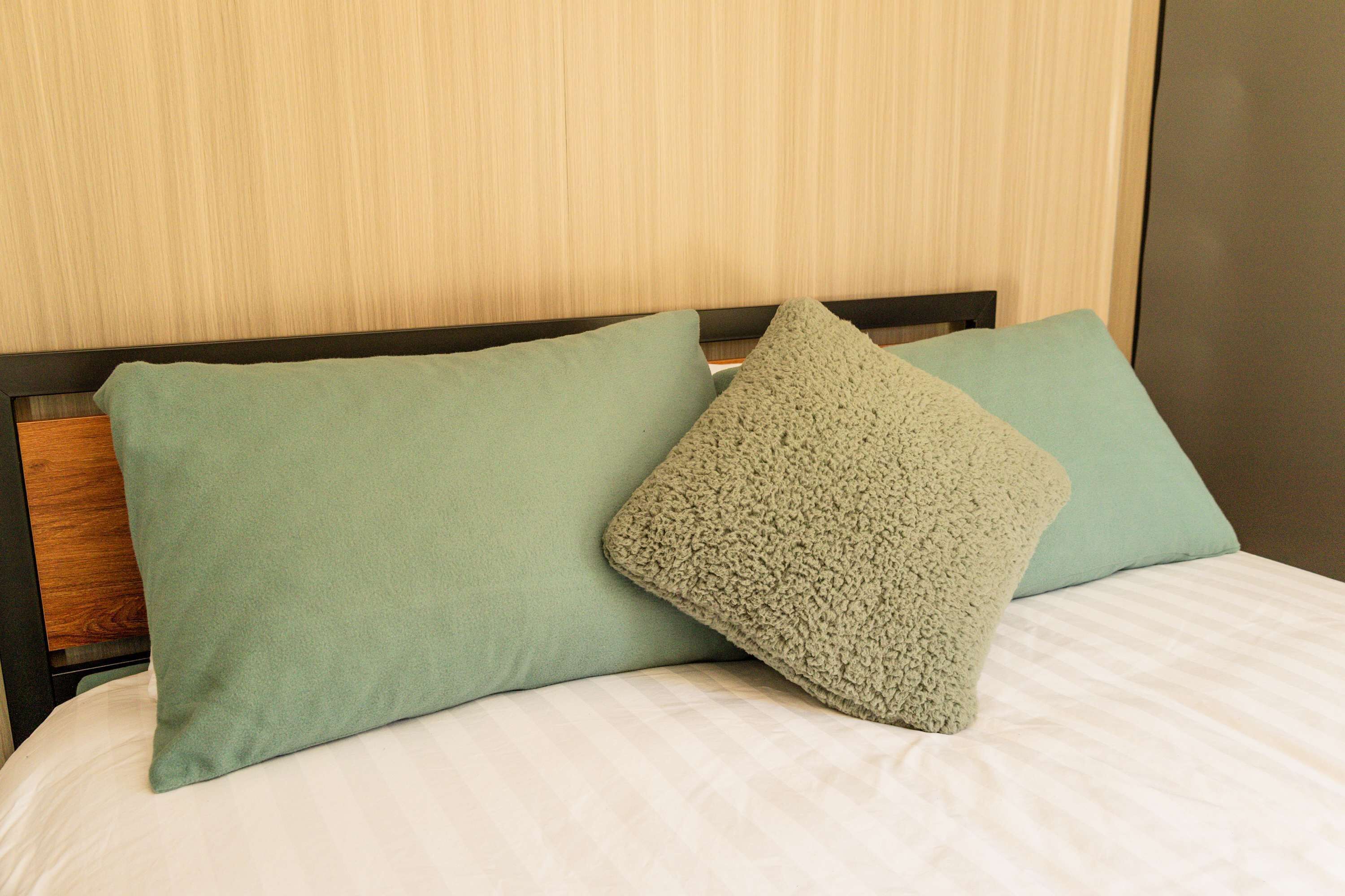 Ein Bett mit zwei Kissen und einem Holzkopfbrett.