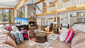 Un salón espacioso con chimenea, un televisor grande y una zona de estar acogedora.