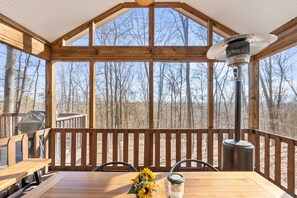 A wooden deck with a table and chairs, a grill, and a wood stove. - Cabin w/hot tub, fire pit & deck (Hedgesville)