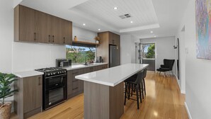 Una cucina moderna con mobili in legno, un'isola centrale e vista sull'esterno.