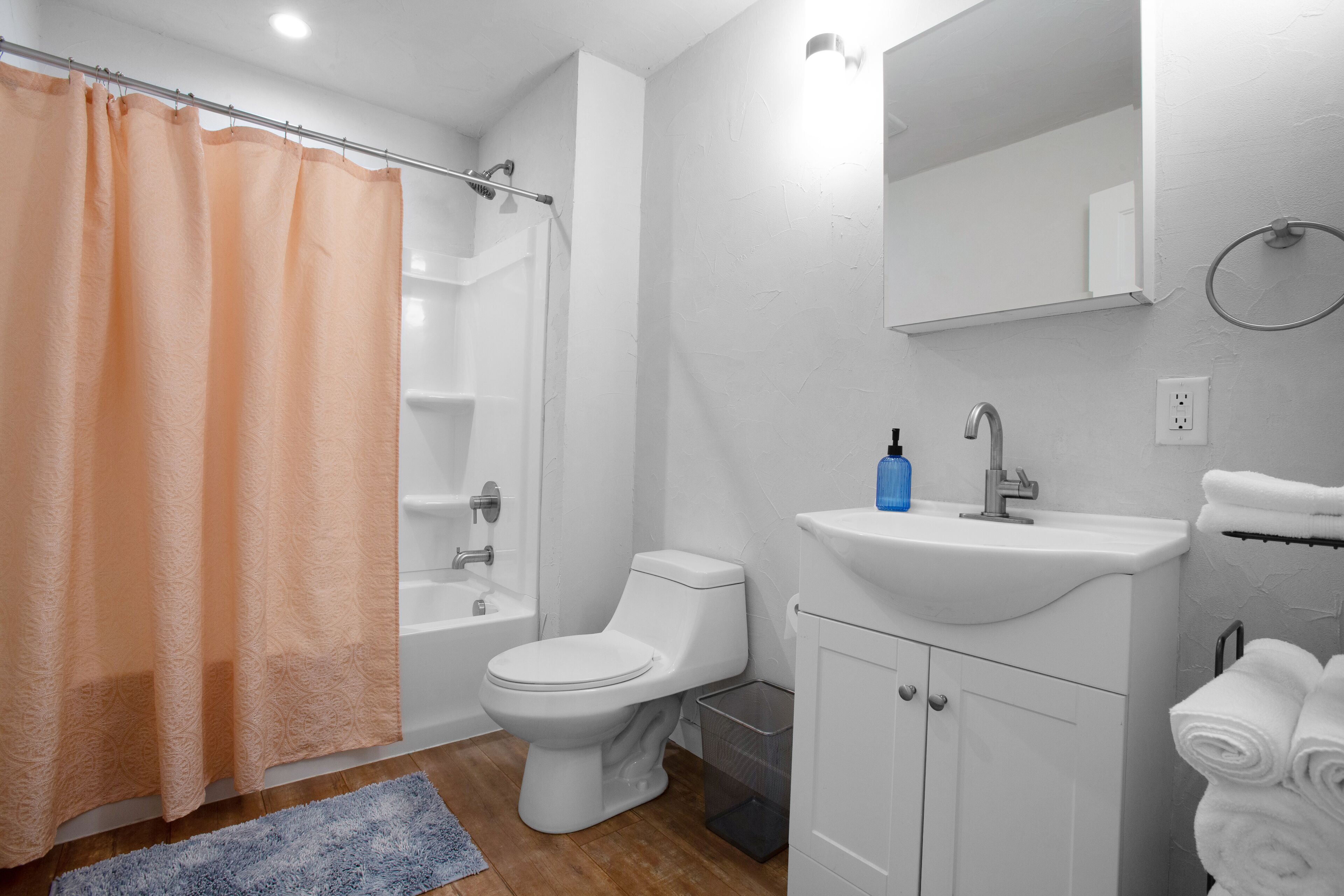 A bathroom with a toilet, sink, and shower.