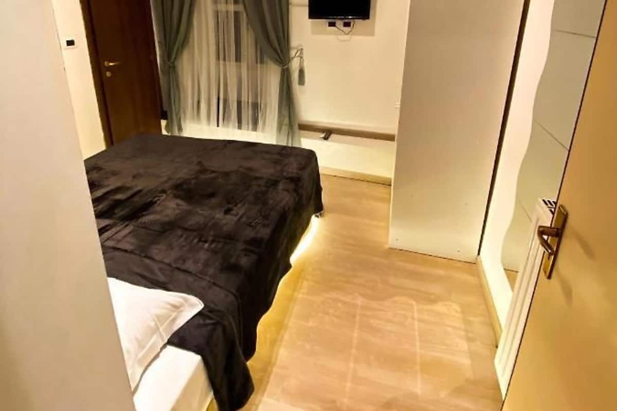 Une chambre à coucher avec un lit, une télévision et une armoire.