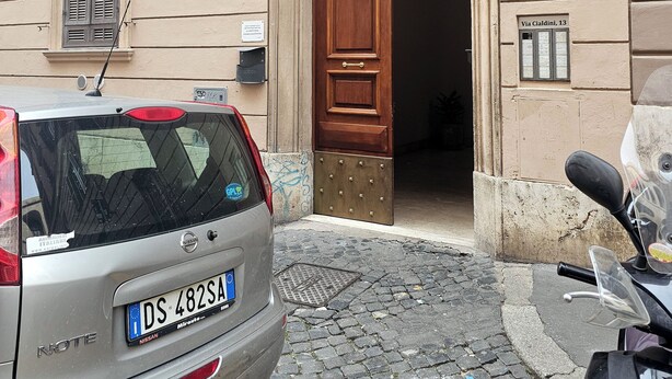 Un edificio con puerta de madera y un cartel que indica 'Area 13'.