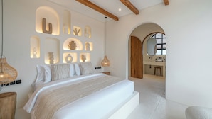 Ein modernes Schlafzimmer mit einem großen Bett, Einbauleuchten und einer Holzbalkendecke.